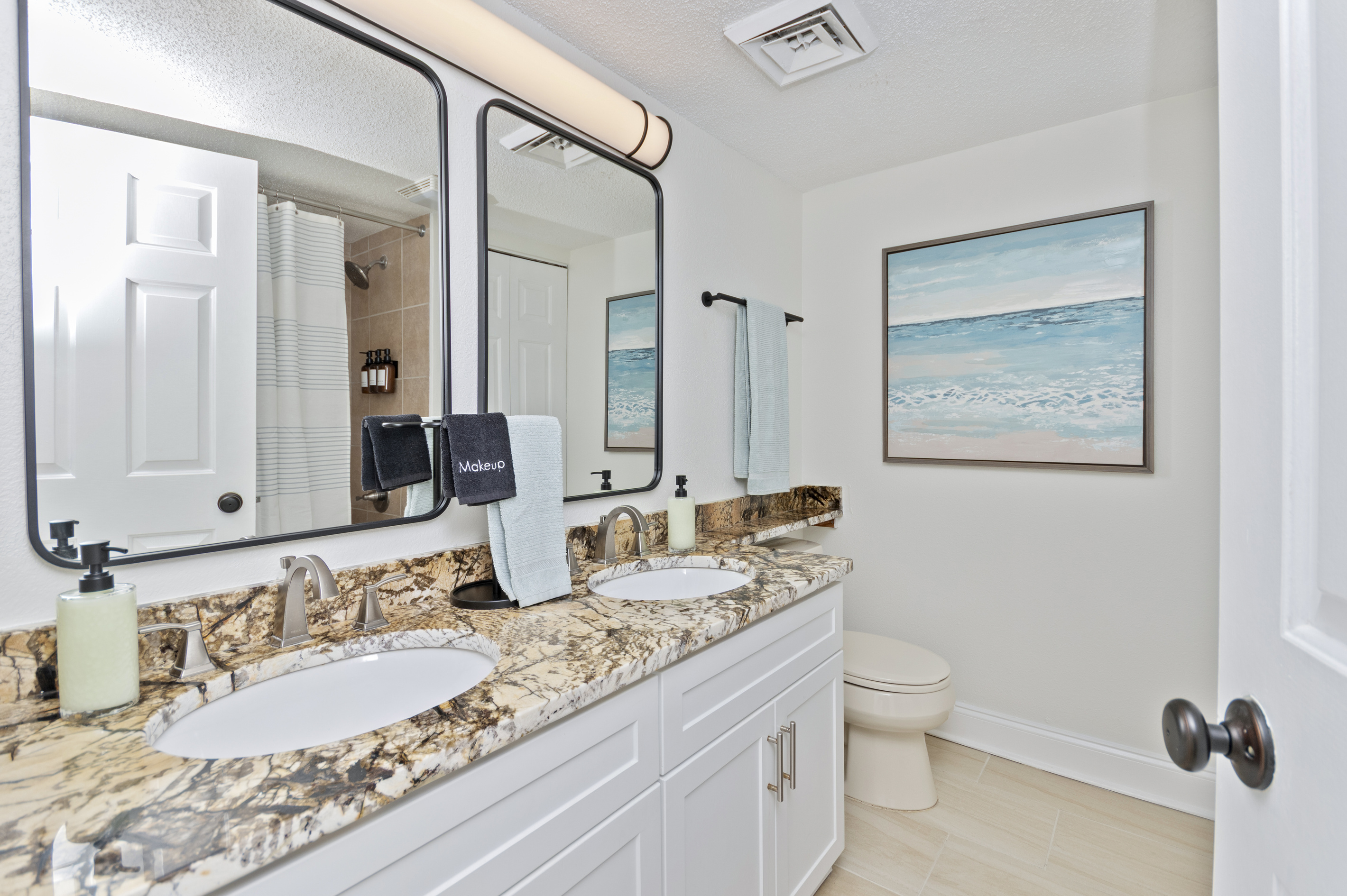 Bathroom stocked with shampoo, conditioner, body wash, plush towels, and first aid kit. 