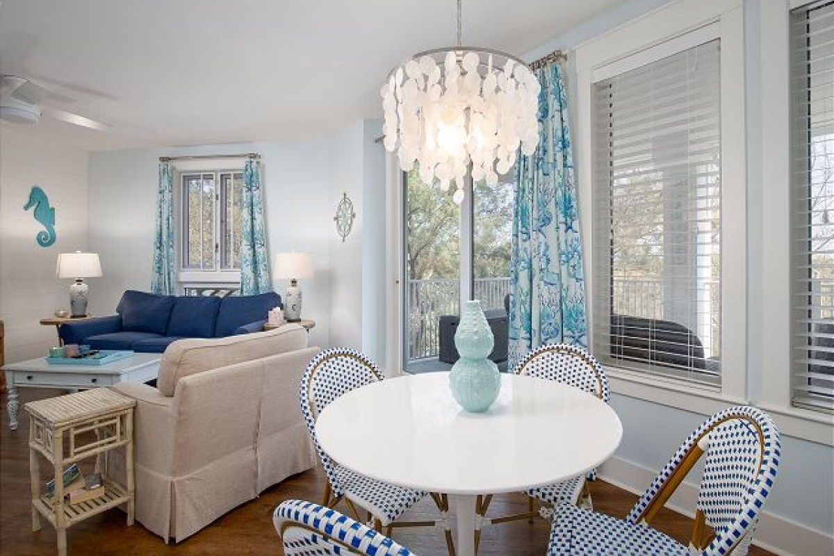 Dining nook with capiz shell chandelier and round table for four beside the living room