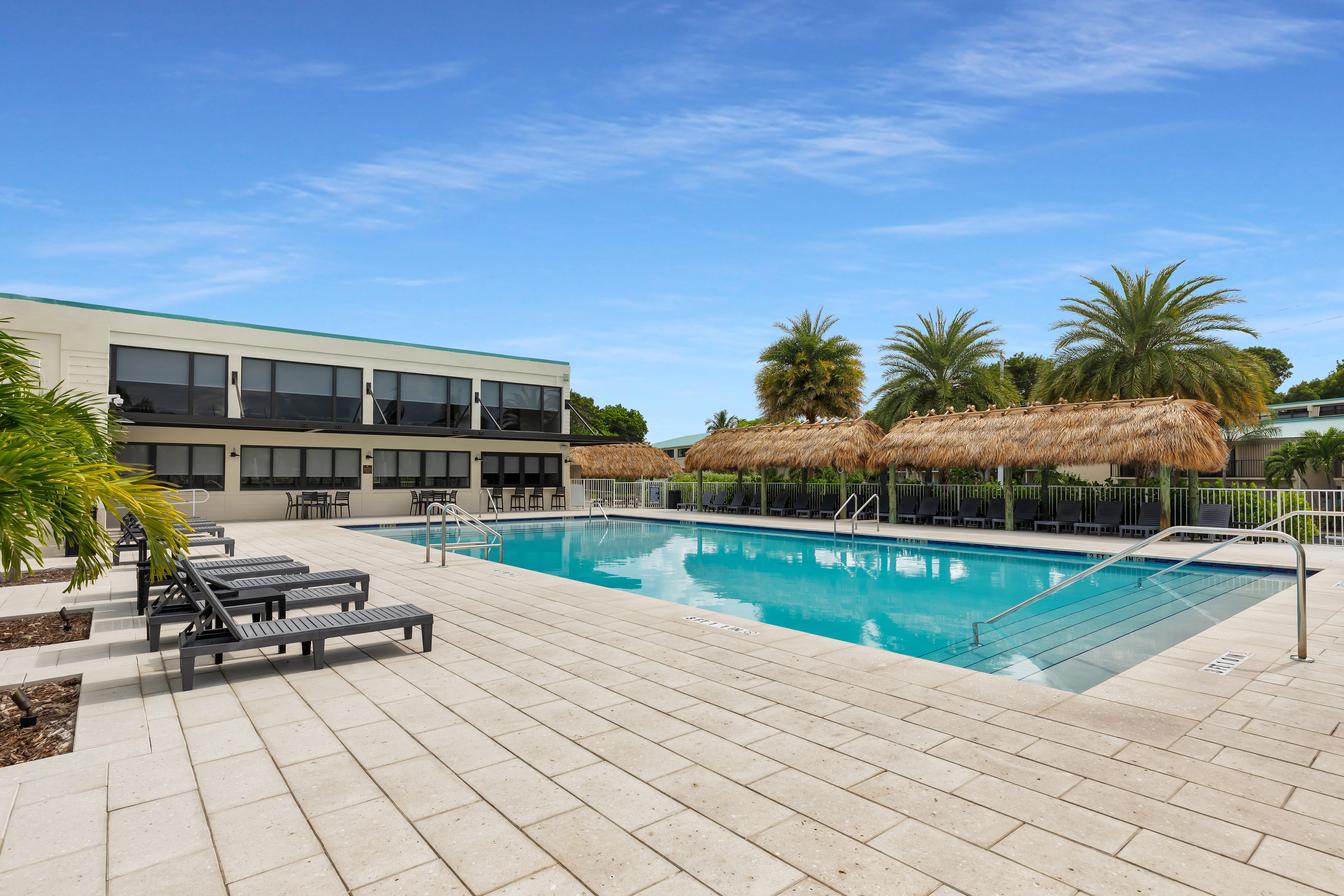 Brand new sparkling pool with plenty of seating and tiki huts for shade