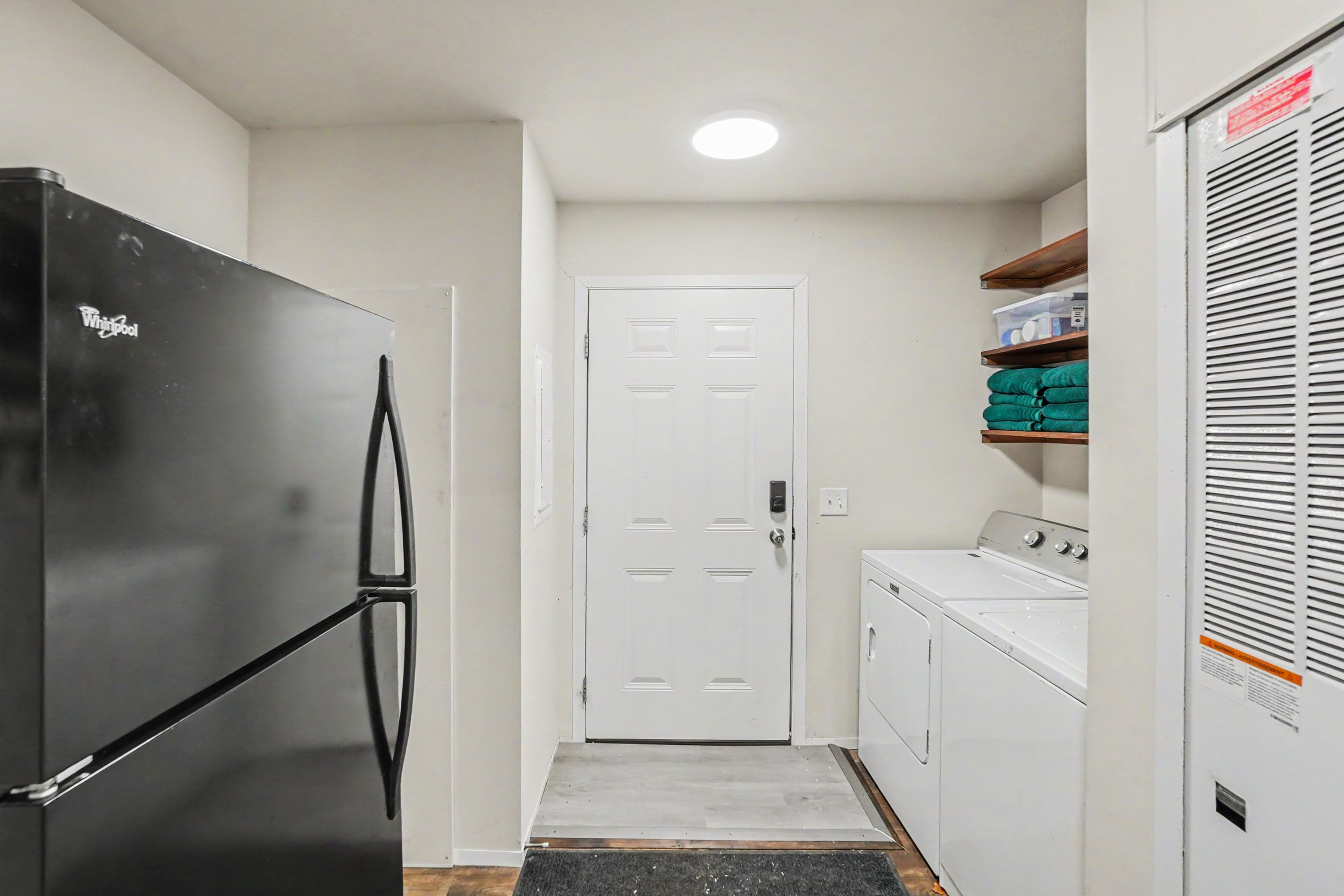 Laundry room with washer and dryer and additional refrigerator.