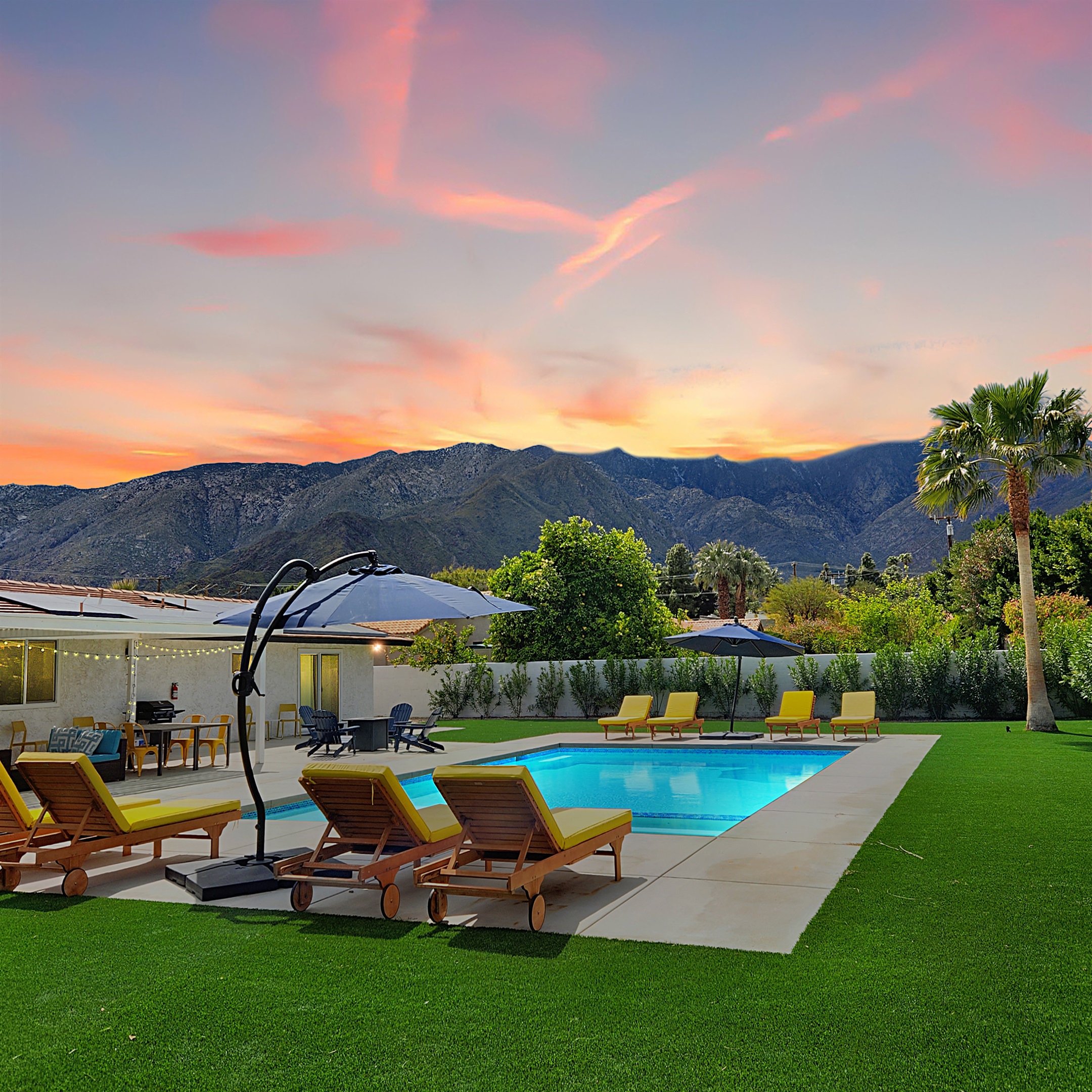 Overlooking the majestic San Jacinto Mountains, this resort-style private yard features a sparkling pool, comfy lounge chairs, and ambient lighting—perfect for sunset relaxation and entertaining guests.
