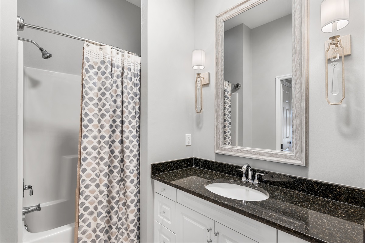 Ensuite bathroom with granite vanity and shower/tub combination