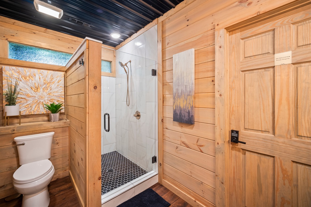 Bathroom-three offers a sleek walk-in shower, modern fixtures, and natural wood accents for a spa-like experience.
