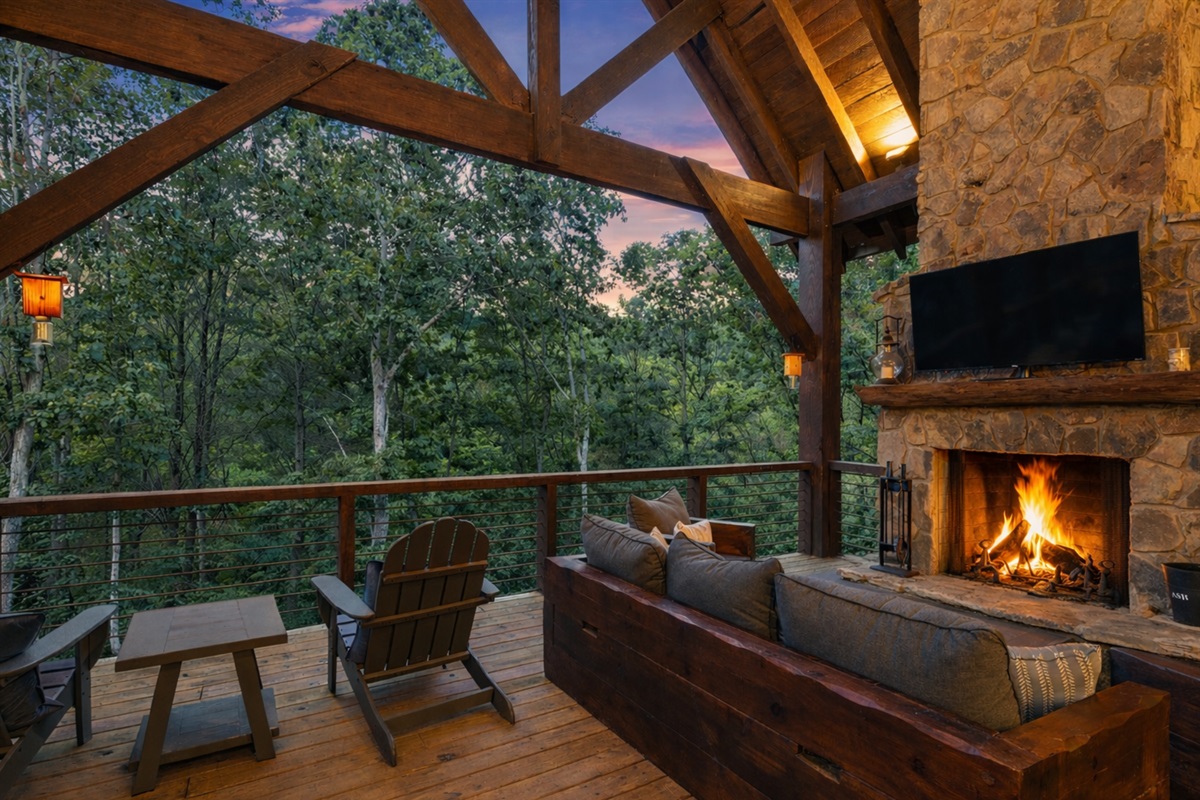 Relax on the covered deck by the stunning stone fireplace, complete with plush seating and views of the surrounding woods.
*Outdoor Fireplace (Available Year Round)