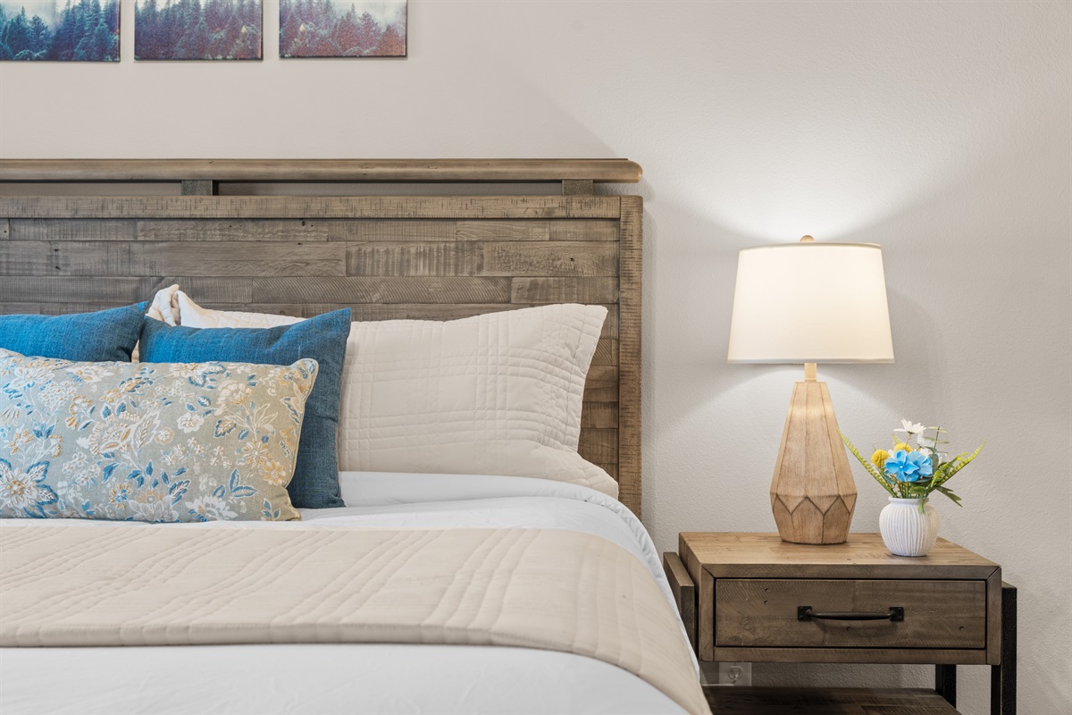 Restful downstairs king bedroom with smart TV and a neutral, calming palette.