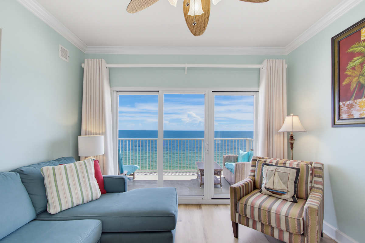 Bright Gulf-front living room with direct balcony access and a TV.