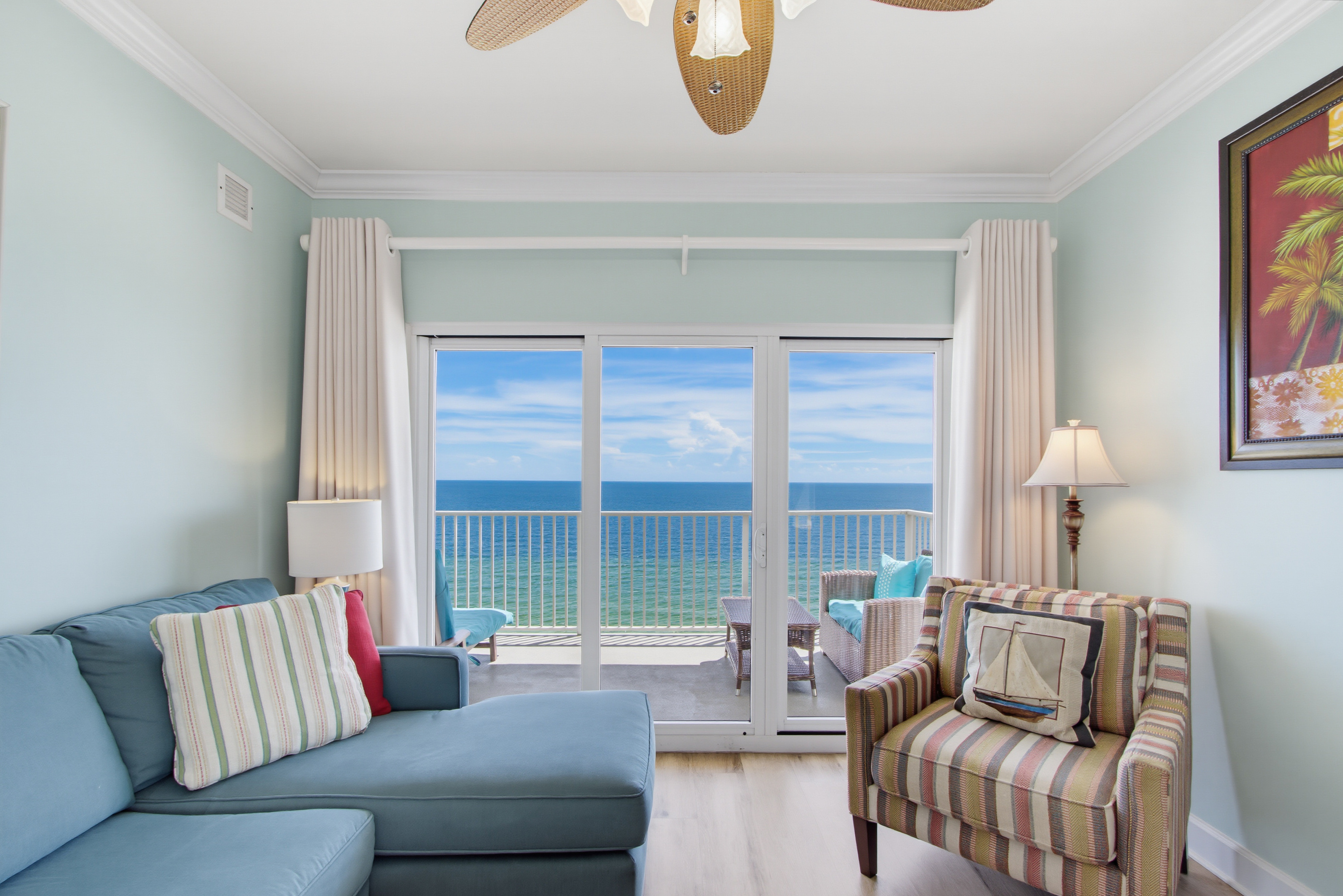 Bright Gulf-front living room with direct balcony access and a TV.