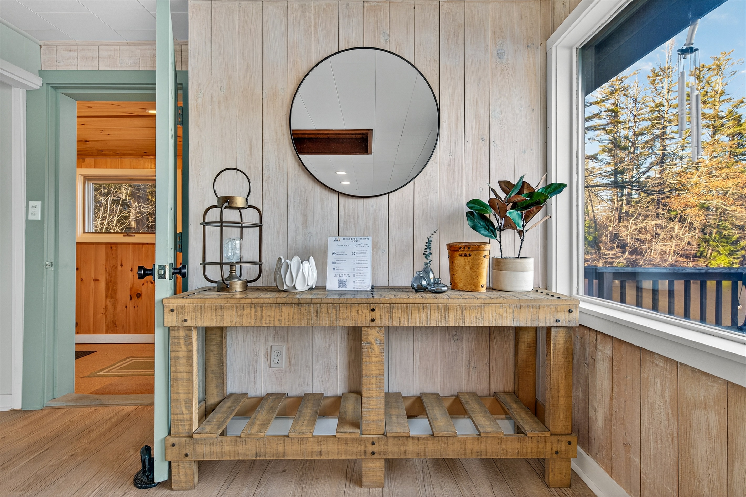 Cozy entry nook with a stylish console table and circular mirror.