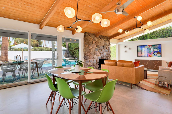 Great room with polished concrete floors, original hand-laid stone fireplace, dramatic lighting and Samsung Frame TV.