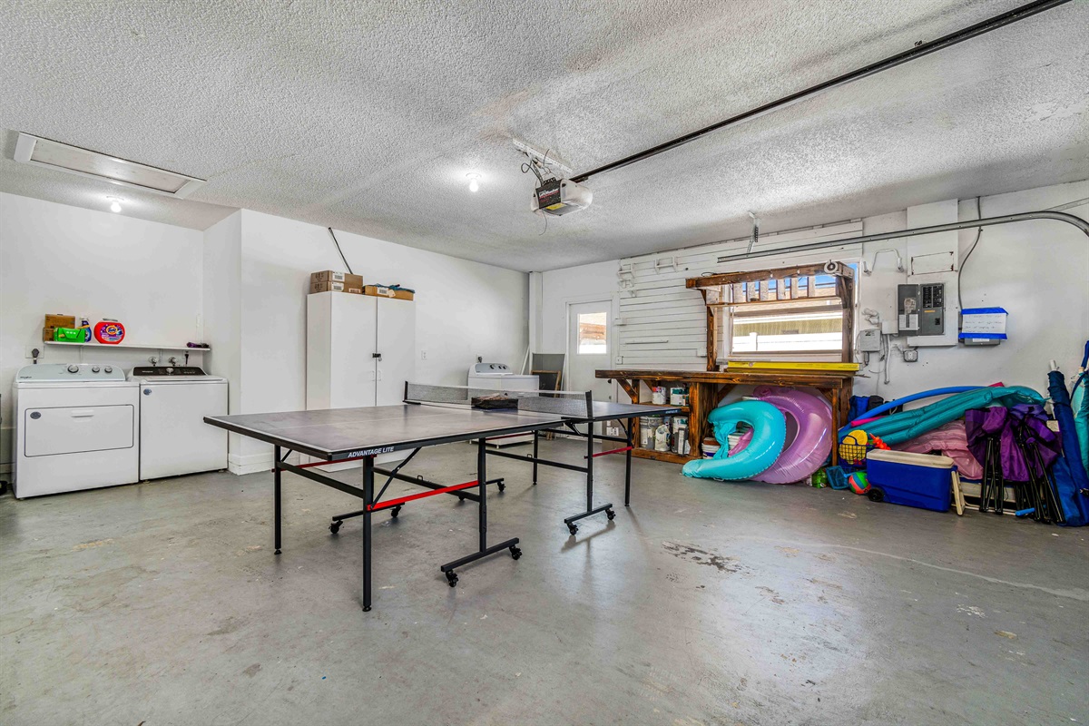 Ping pong table, beach and pool toys, and washer and dryer in the garage