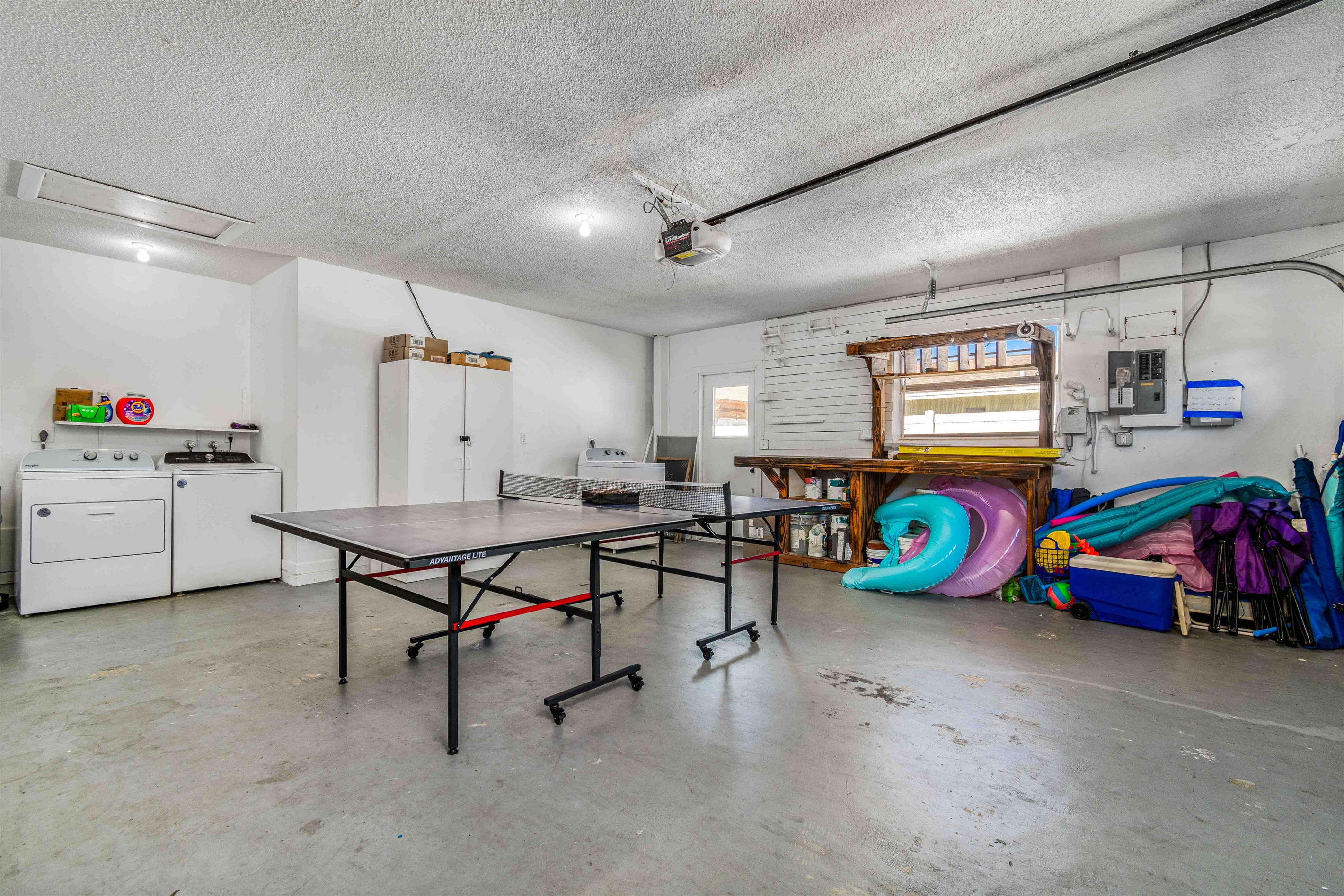Ping pong table, beach and pool toys, and washer and dryer in the garage