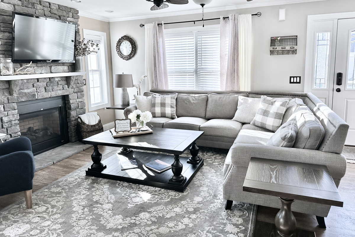 This living room is all about comfort. The big, plush sectional is perfect for sinking into, and the stone fireplace makes the whole room feel so warm and inviting. It’s a bright, open space where you can really just kick back and relax.