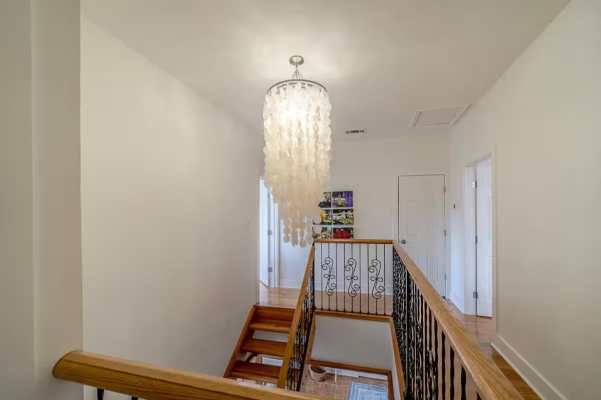 Spacious second-floor landing connecting the upper bedrooms and featuring a gorgeous modern chandelier