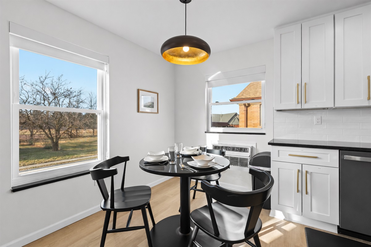 Bright, modern dining nook with sun-filled windows, sleek finishes, and a cozy table—perfect for morning coffee or intimate meals at home.