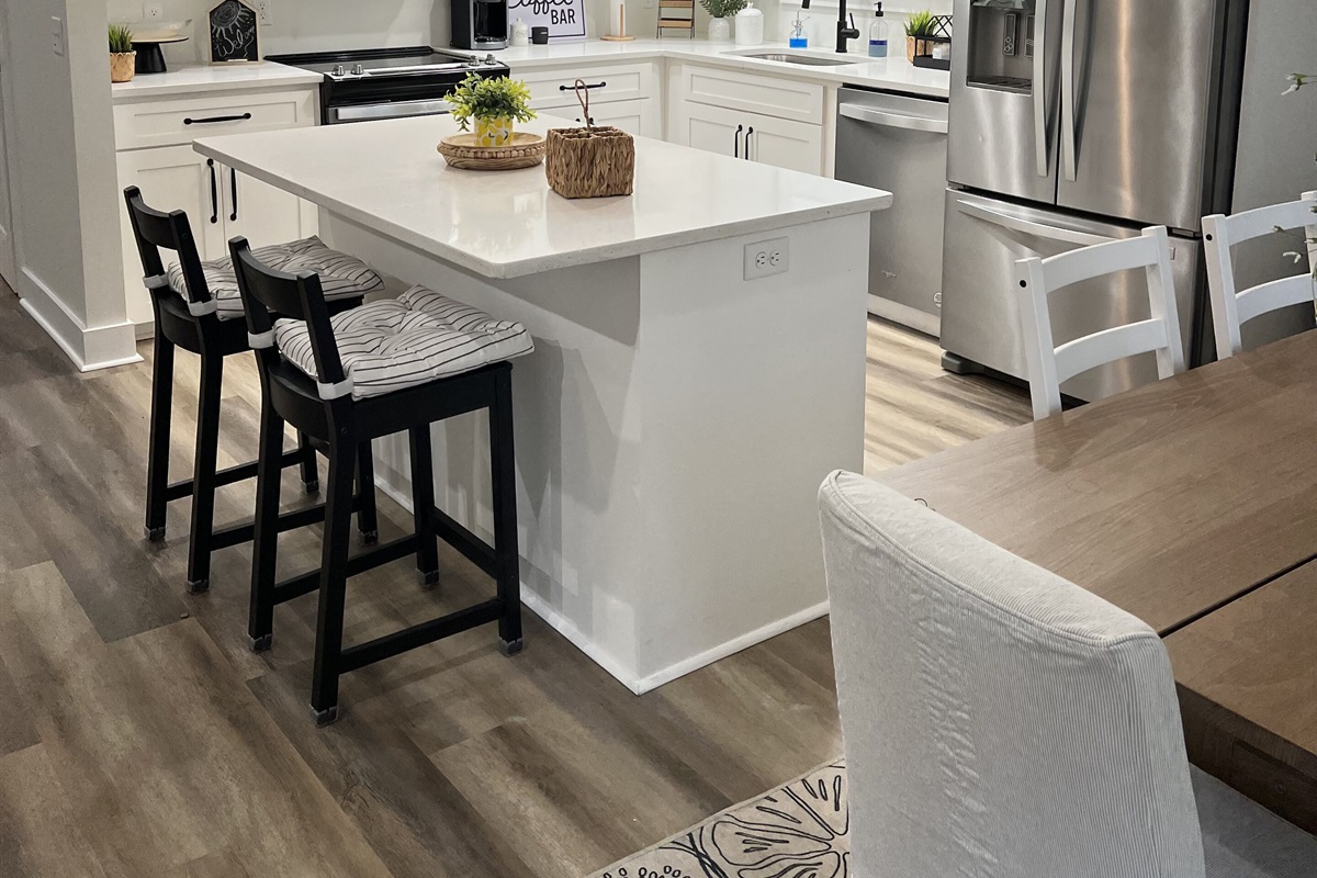 The spacious kitchen includes an island with 2 stools.