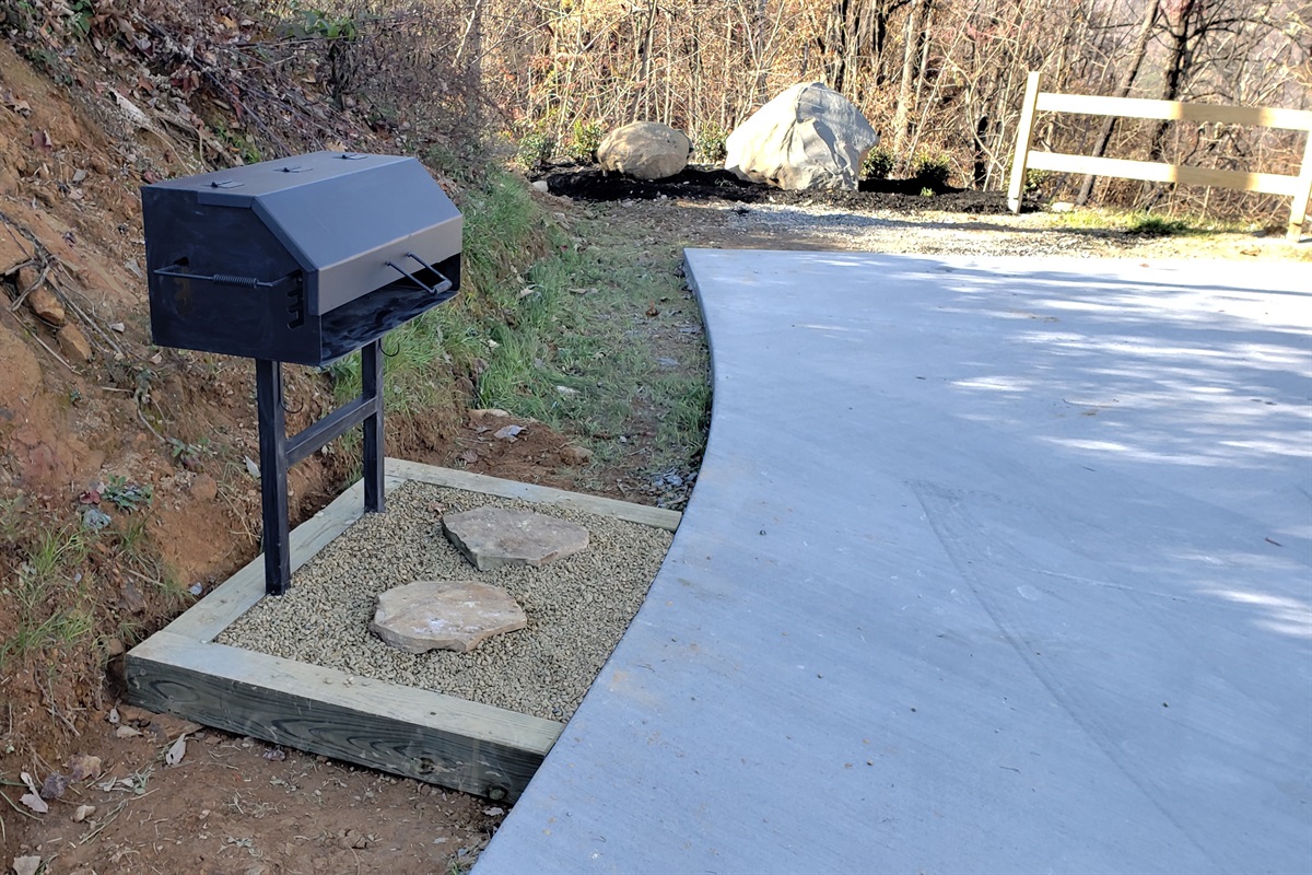 A large charcoal grill in the front yard