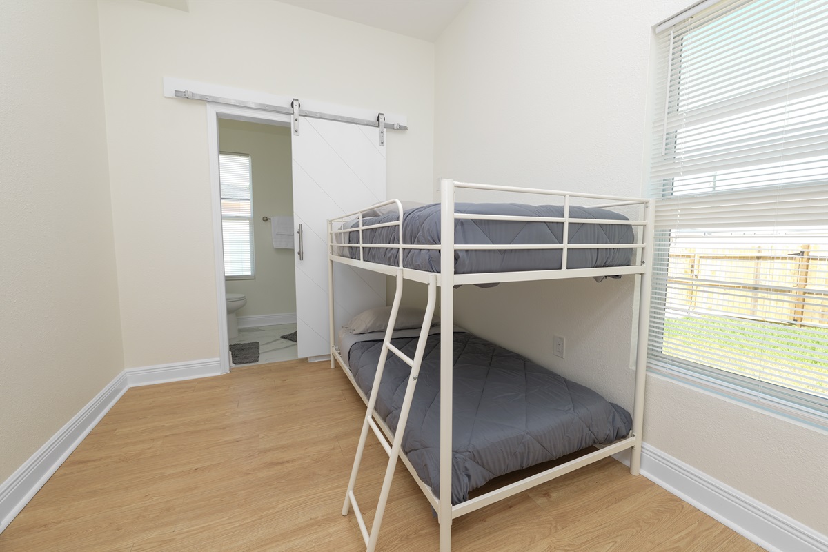 Fun and functional, this bunk room is ideal for kids or teens—complete with natural light and easy access to a modern bathroom.