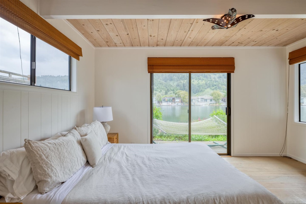 - Spacious king bedroom with sliding doors opening to a scenic waterfront  
- Wake up to calming water views right from the comfort of your bed  
- Dual windows and wood ceiling keep the space bright and welcoming  
