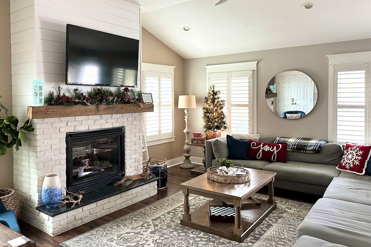 Decorated in November, the home features a cozy fireplace, festive snowflake pillows on the sofa, and a sparkling Christmas tree, creating the perfect atmosphere for a relaxing seasonal stay.