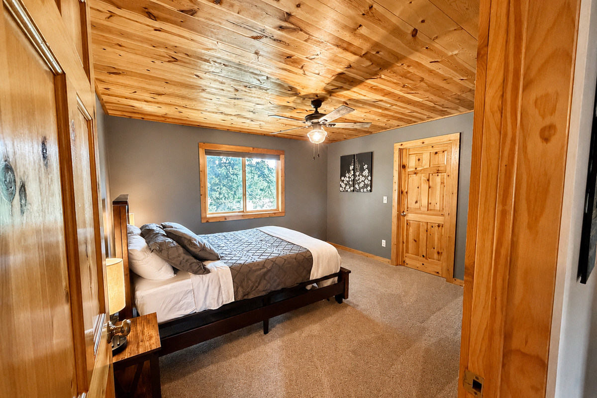 Warm wood ceilings and rustic finishes give this private bedroom a comfortable Northwoods feel. This spacious bedroom has a large walk in closet and room to spread out.