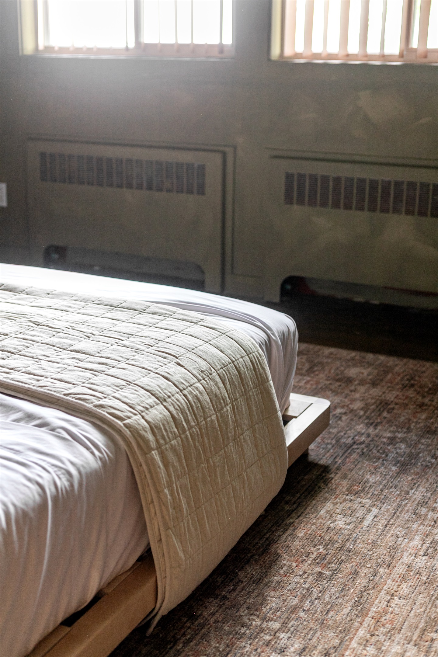 This queen-size bedroom combines cozy design with modern simplicity. The low platform bed creates a sleek, inviting look, while bedside tables and a lamp add convenience.