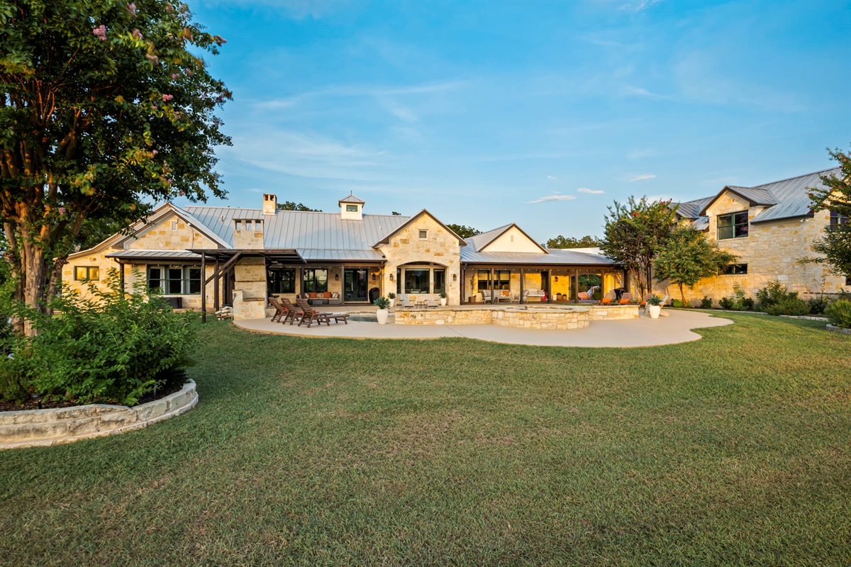 Spacious backyard featuring a stone patio and a lush, well-maintained lawn.