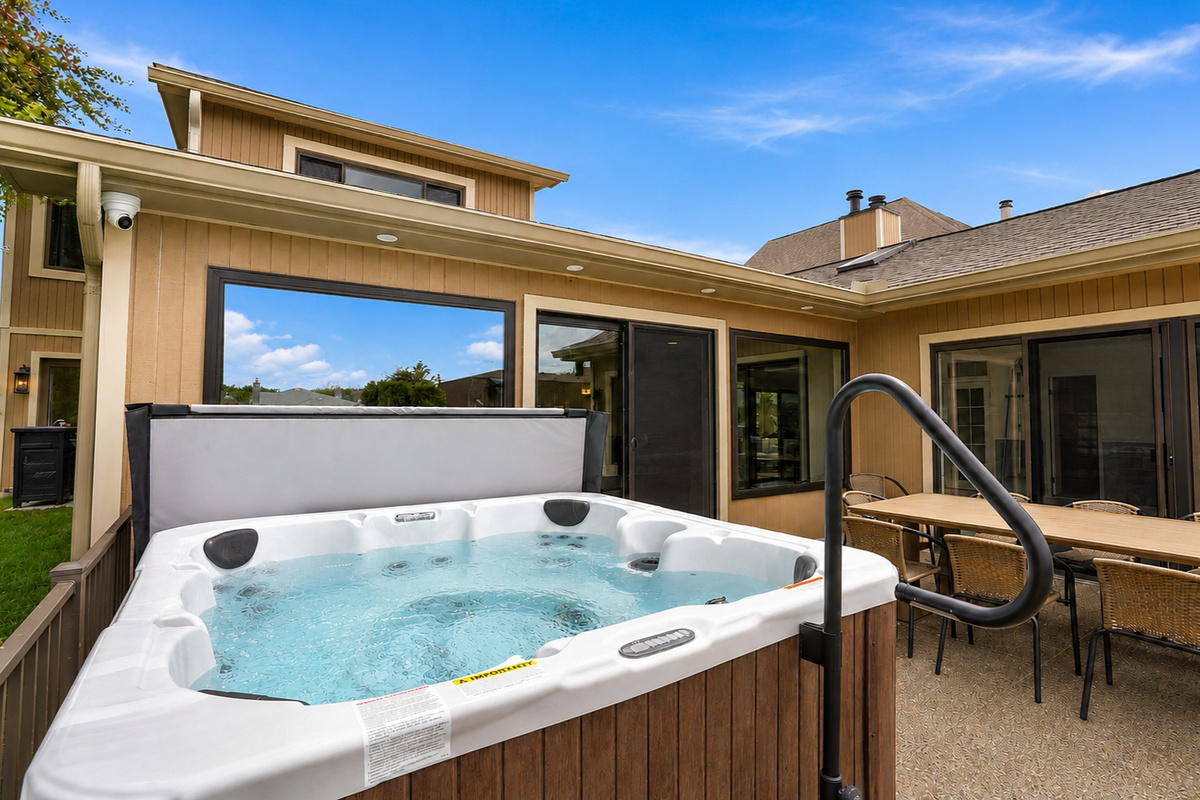 Private outdoor hot tub patio with seating and indoor-outdoor access. Relaxing, resort-style space perfect for unwinding and enjoying a peaceful stay.