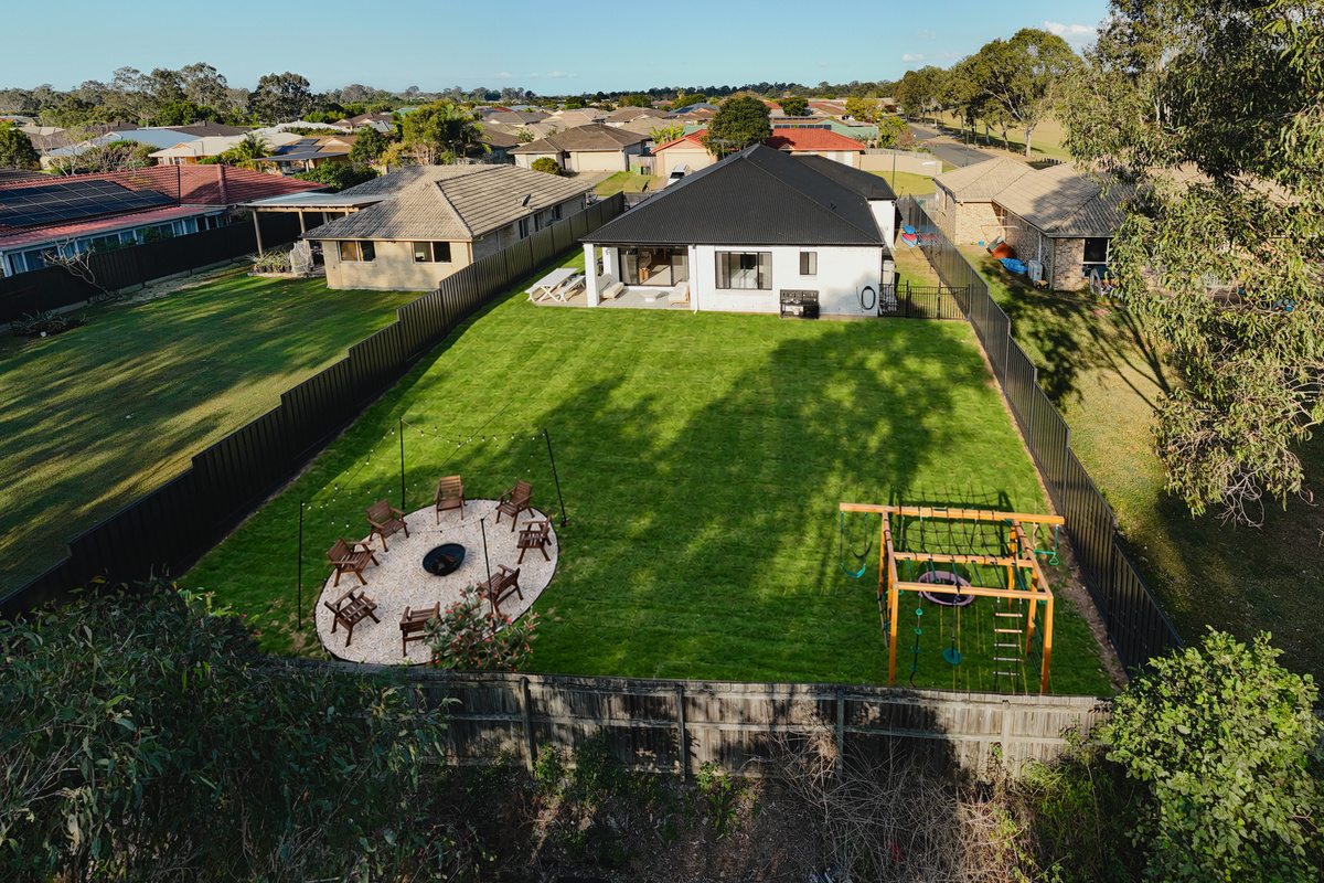 A bird’s-eye view of the generous backyard, complete with a fire pit, seating and children’s play area.