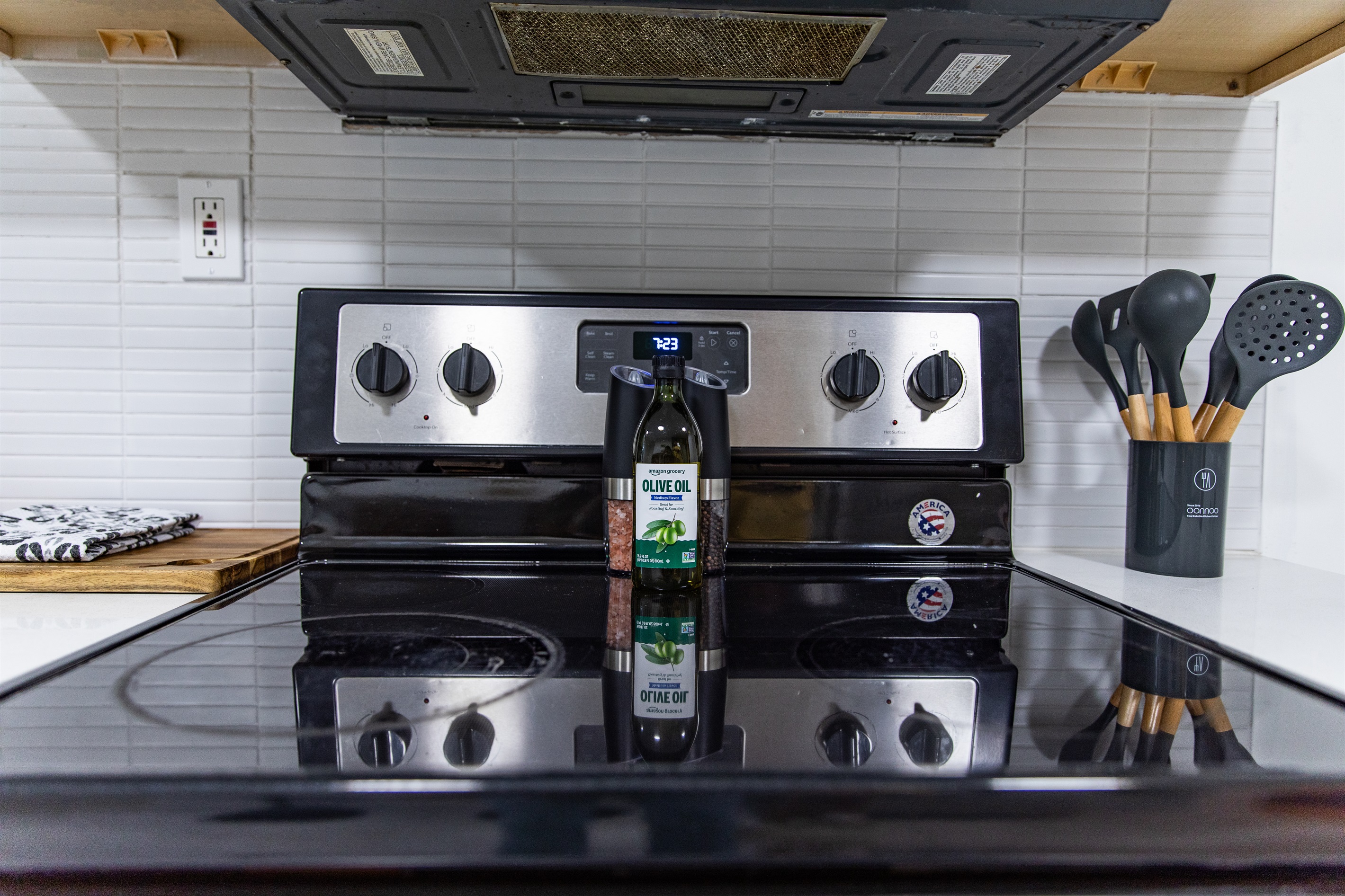 Kitchen detail with stainless steel stove, cooking essentials, and modern backsplash for a practical yet stylish touch