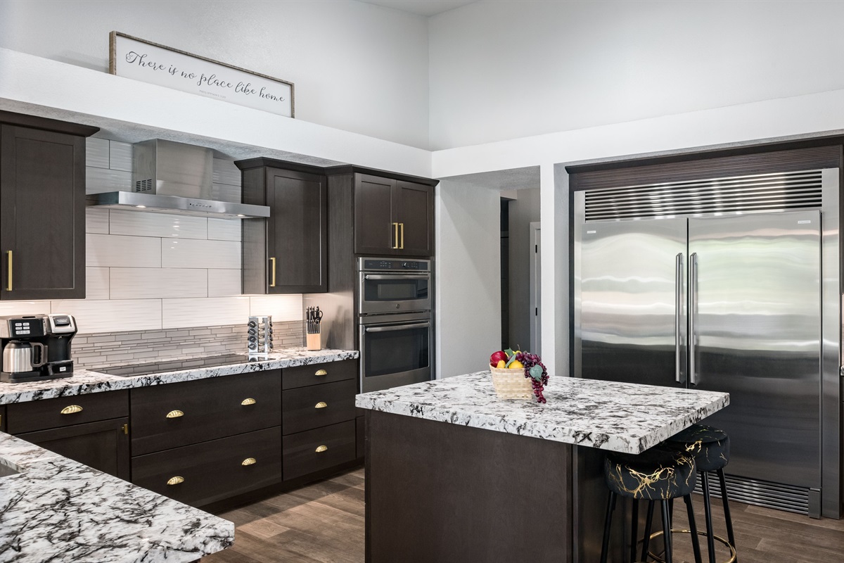 The gourmet kitchen includes high-end appliances, a commercial-grade fridge, and a sleek island perfect for family meals or entertaining.
