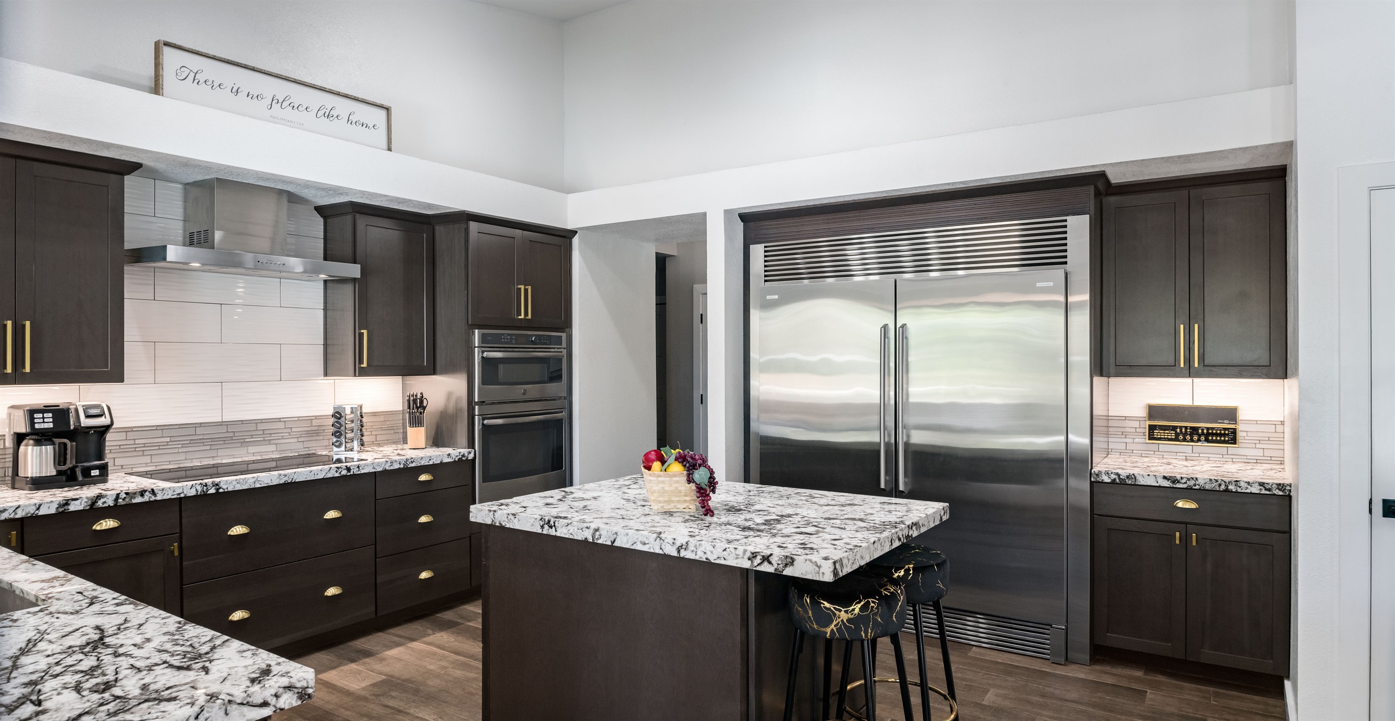 The gourmet kitchen includes high-end appliances, a commercial-grade fridge, and a sleek island perfect for family meals or entertaining.