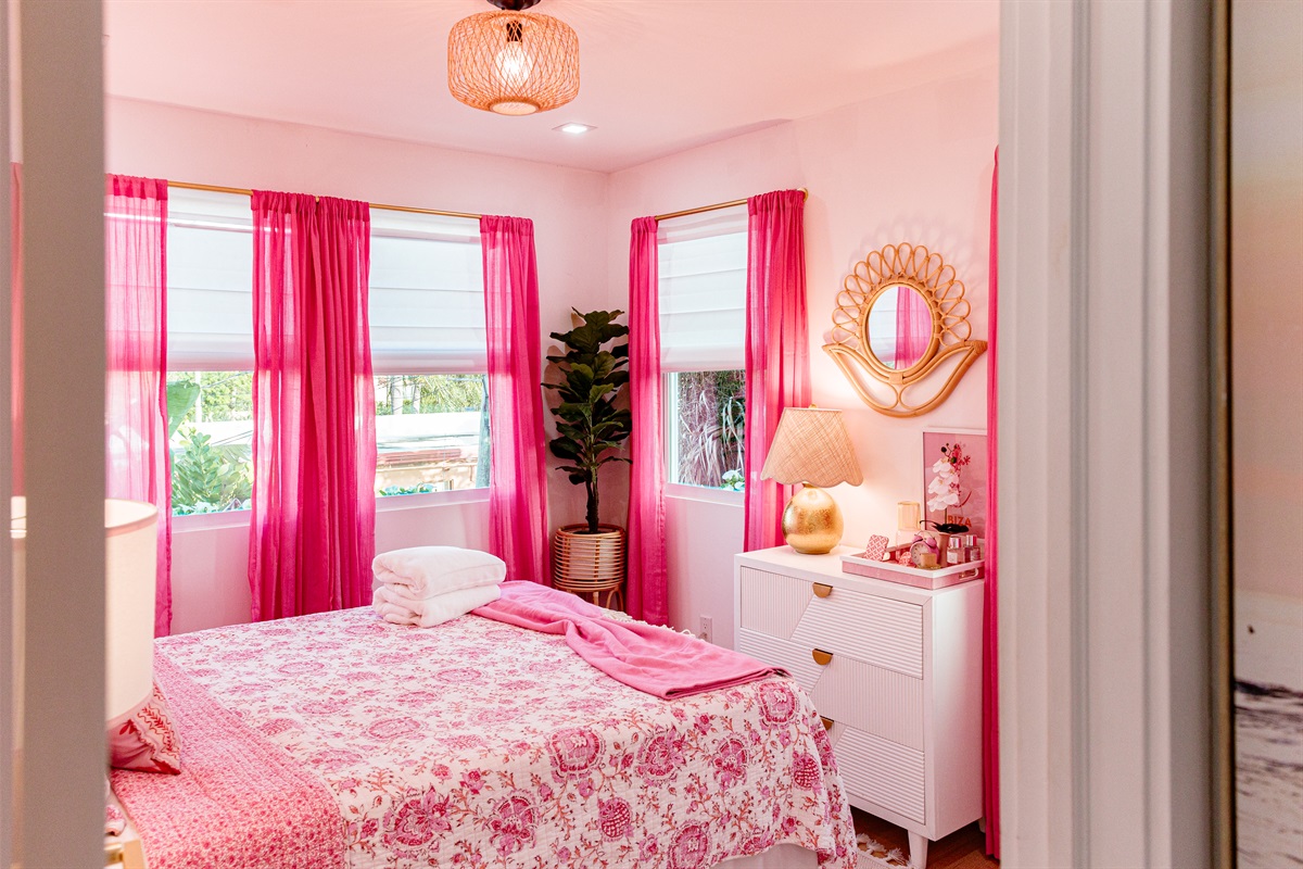 The second cottage bedroom is draped in themes of red and pink, a colorful and comfortable place to relax for a long evening's rest.