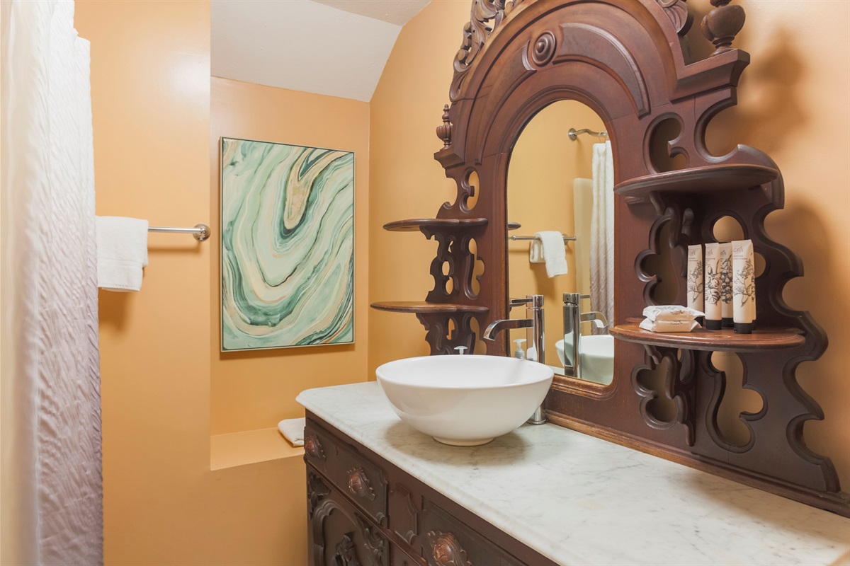 A beautiful wood vanity adds warmth and character to the bathroom’s design.