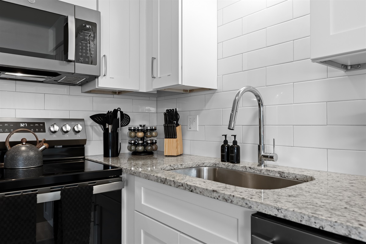 Bright and functional kitchen with granite counters, subway tile backsplash, and stainless steel appliances.
