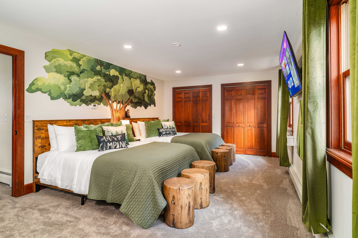 🏕 Camping Room: two queen beds, a hand-painted tree, log stools and a 55" HDTV — the kids' favorite room in the house.
