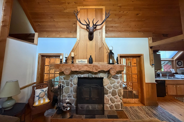 Full view of fireplace with doors to cottage front seating area and cottage entrance