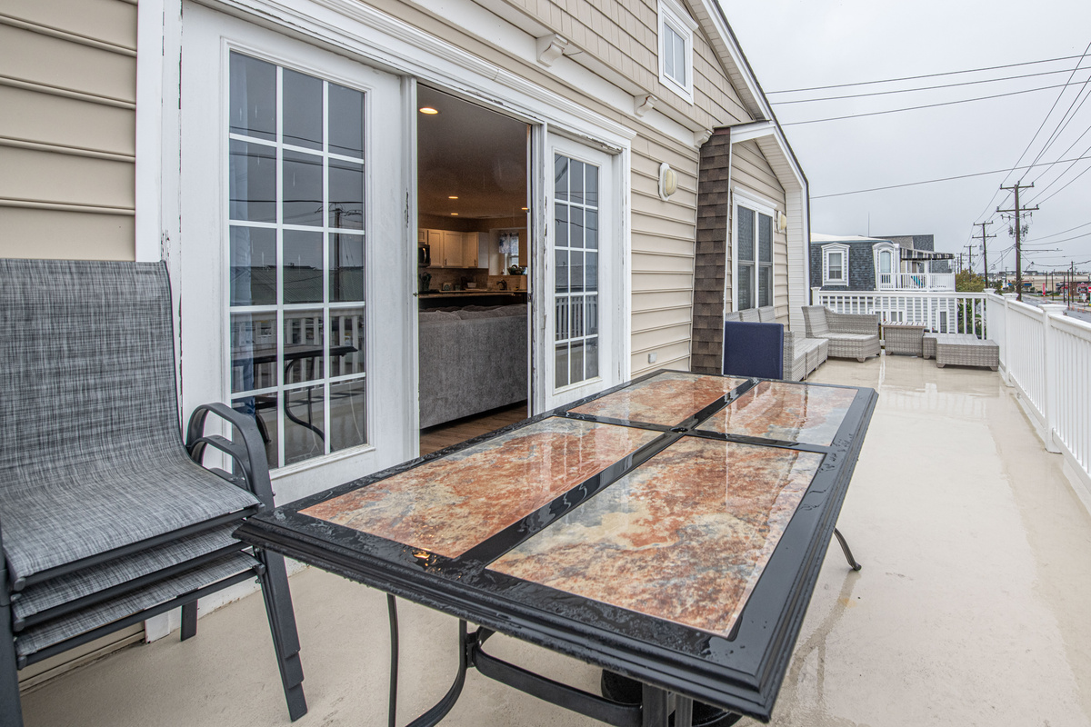 Outdoor Deck with Glass-Top Dining Table and Patio Seating
