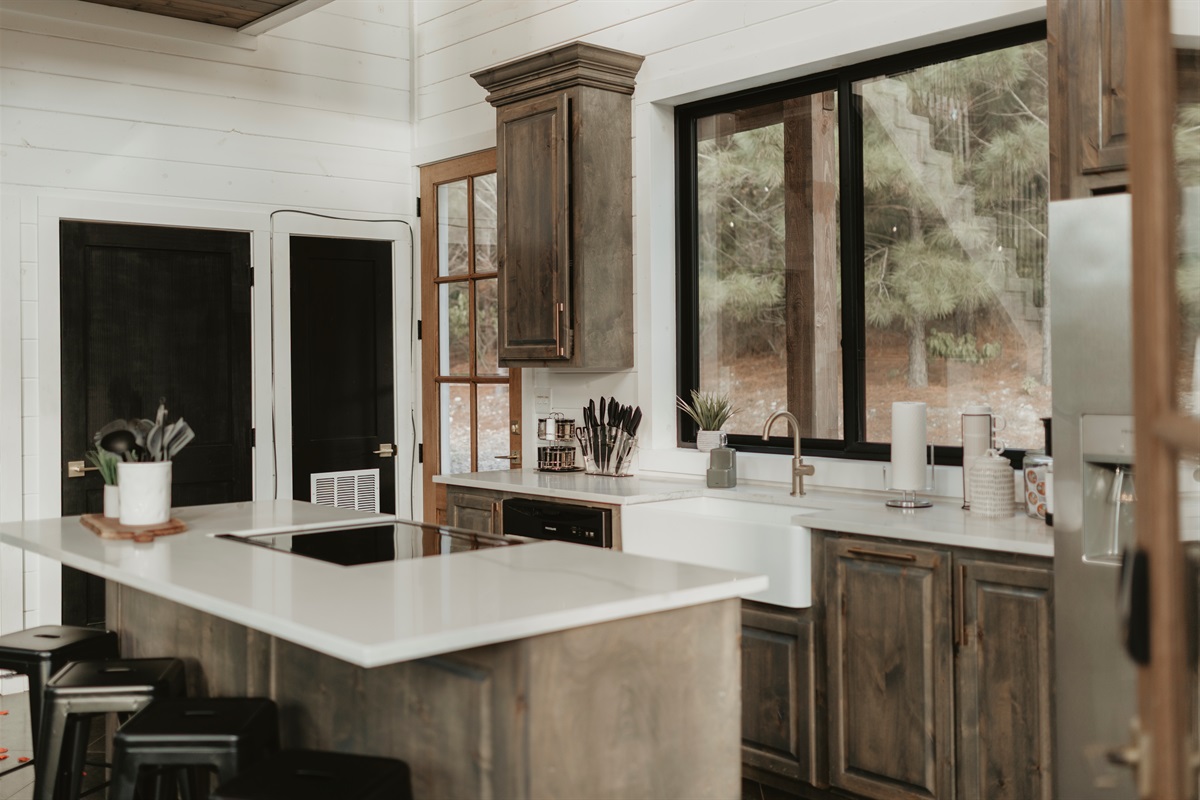 From morning pancakes to midnight snacks, this dreamy kitchen is made for gathering, grazing, and good conversations—framed by warm wood tones and forest views.