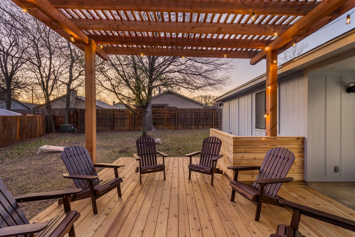 Unwind beneath soft string lights as the evening settles in, with warm wood tones and open skies setting the mood. This is where slow conversations and quiet moments come naturally.