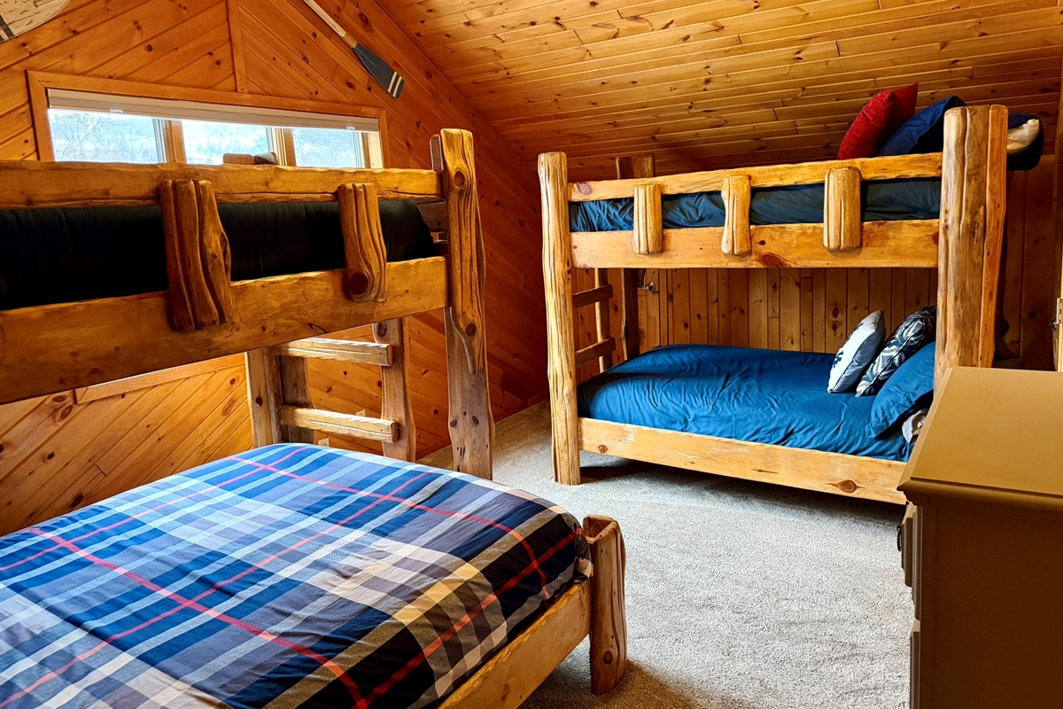 Upstairs bunk room with two bunk beds and a dresser, an awesome setup for kids, cousins, or the whole crew to crash comfortably after a full day of North Shore adventures.
