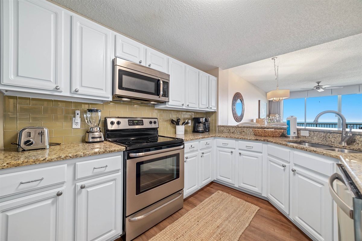 This fully functional kitchen boasts stainless steel appliances, sleek countertops, a decorative backsplash, and ample cabinet storage, ideal for everyday cooking and entertaining.