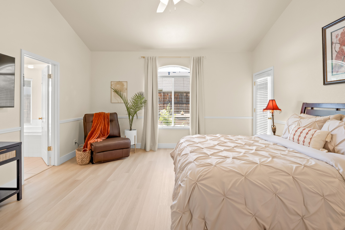 Enjoy restful nights and peaceful mornings in this bright and airy bedroom. The comfortable bed, cozy recliner, and calming décor create a welcoming space you'll love coming back to each day.