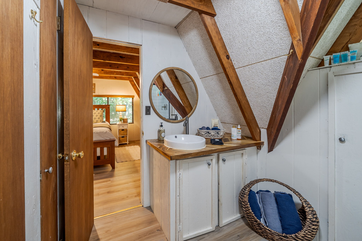 Your morning routine gets the full A-frame treatment — angled ceiling over the vanity, vessel sink, and actual elbow room.