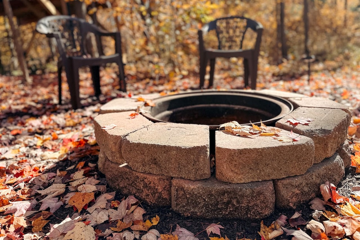Cozy fire pit, with plastic chairs, perfect for relaxing evenings under the stars. Ample seating for everyone.