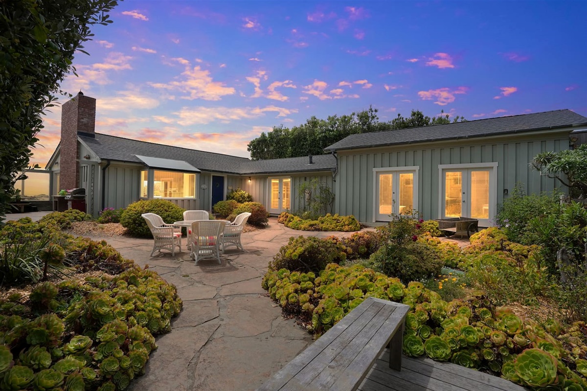 - Stunning courtyard with stone patio, beautiful greenery, and multiple seating areas  
- Surrounded by the home’s charming architecture for a private outdoor retreat  
- Warm evening lighting sets the perfect mood for dining or relaxing outdoors  