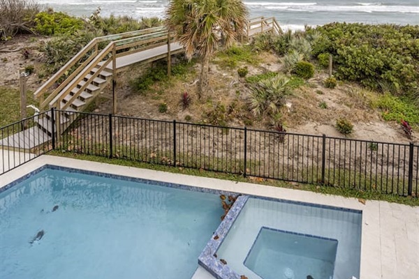 Enjoy the exterior of the house with a sparkling swimming pool, offering a beautiful view of the ocean and a charming bridge leading directly to the sea, creating a perfect blend of tranquility and coastal beauty