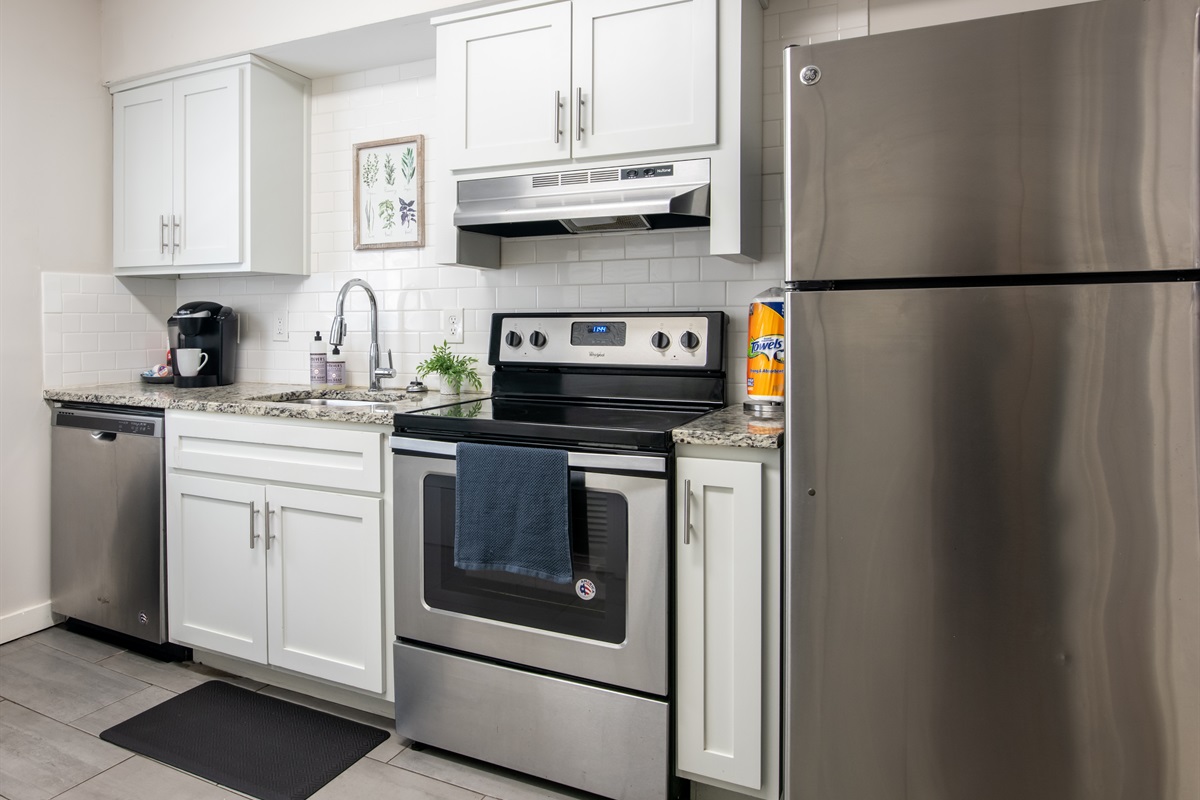 Modern kitchen setup with stainless steel appliances, including oven, fridge, and coffee maker.