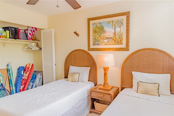 Guest bedrooms with 2 single beds and a lot of beach supplies.