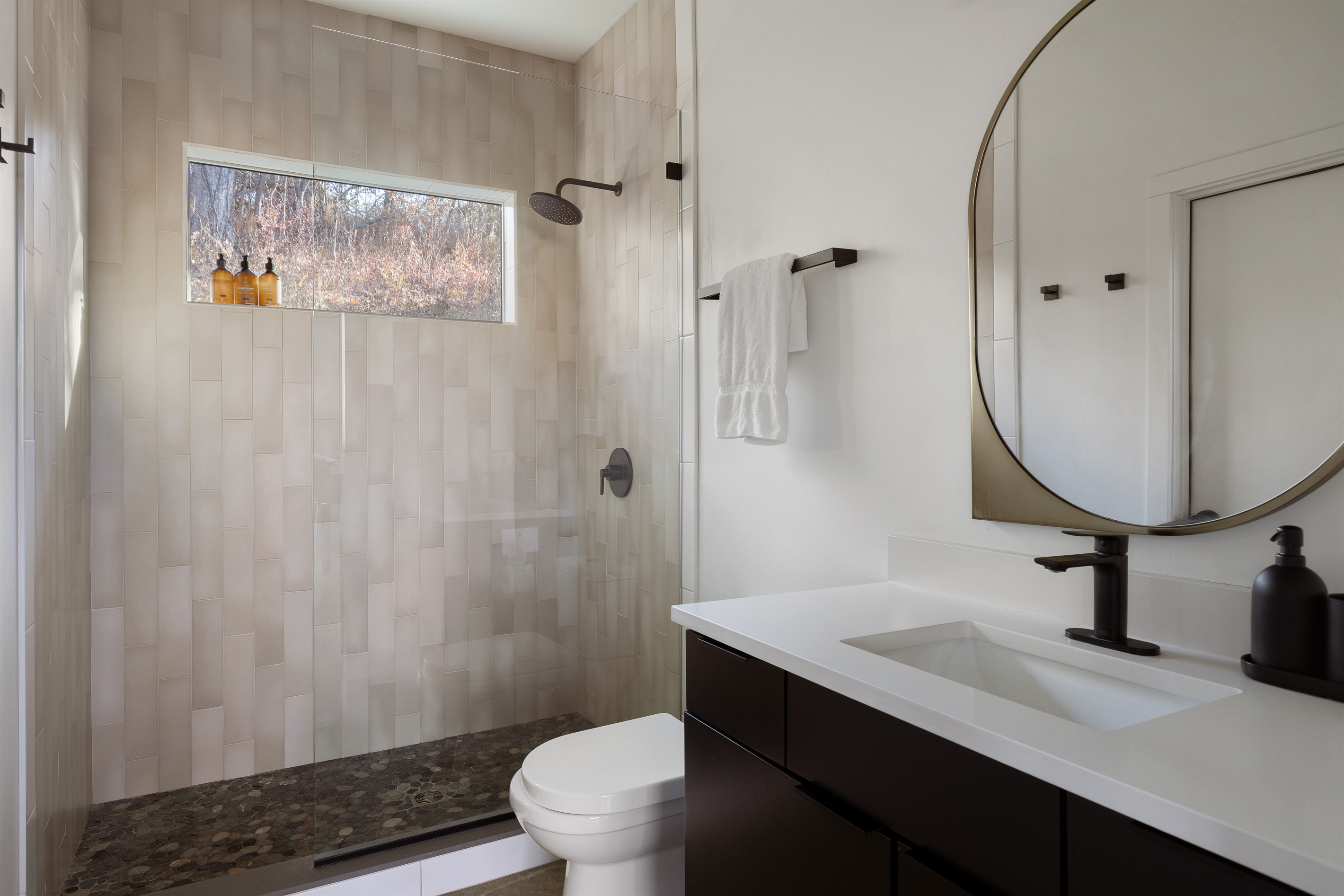 {Casita Bathroom - Glass House} Spa-like ensuite with a walk-in shower, modern fixtures, and Public Goods toiletries for a refreshed start to each day