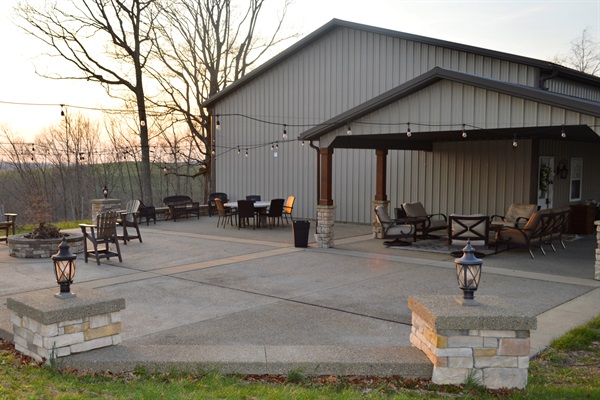 Spacious outdoor patio with fire pit, dining area, and covered seating